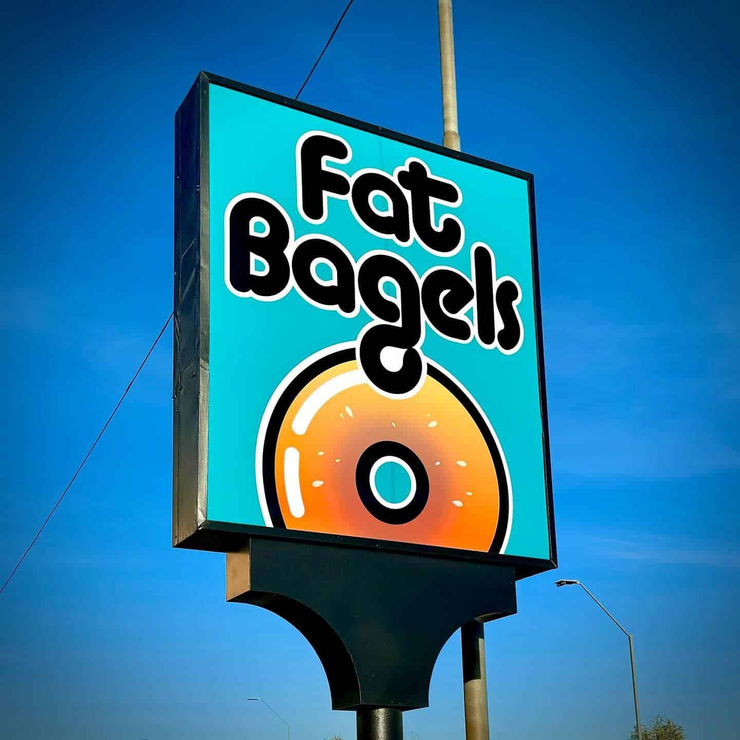 Fat Bagels' sign on Route 66 at dusk.